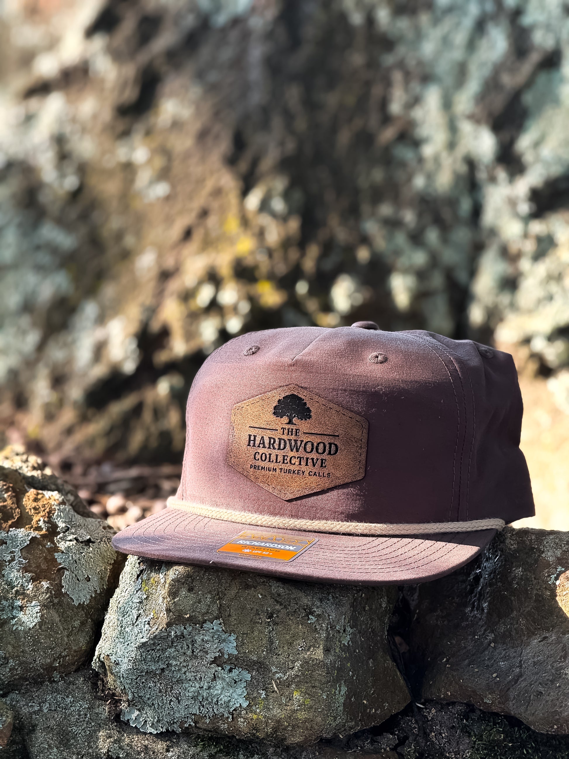 Brown cap with a logo on a stone surface
